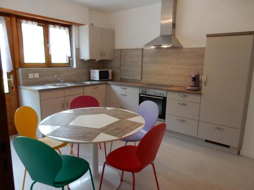une cuisine avec une table et des chaises colorées dans l'établissement GITE KIENTZLER, à Ribeauvillé