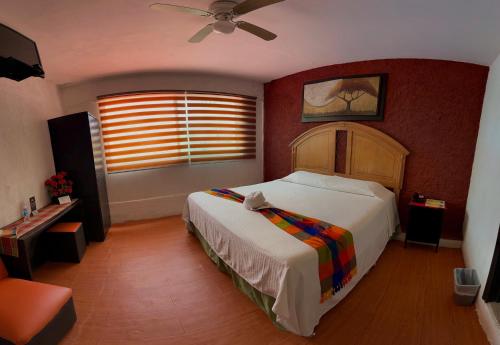 a bedroom with a bed and a ceiling fan at Hotel Makarios in Tuxtla Gutiérrez