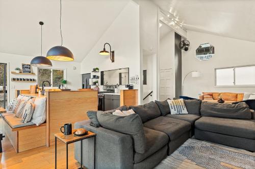 a living room with a couch and a kitchen at Modern Treetop Cabin by Lake Arrowhead Village in Lake Arrowhead