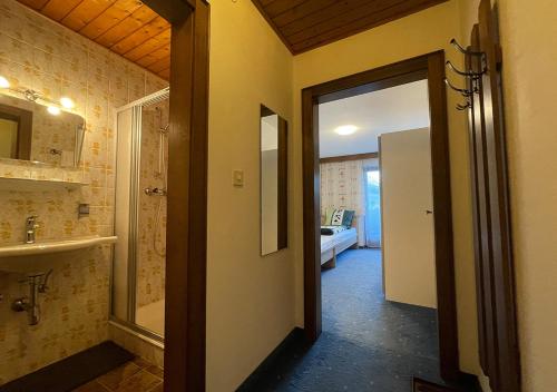 a bathroom with a sink and a door to a room at Pension Berta in Waidring
