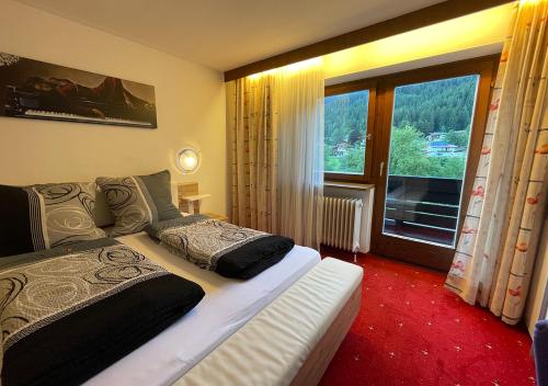 a bedroom with a bed and a large window at Pension Berta in Waidring