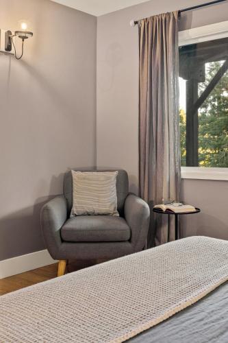 a bedroom with a chair and a window at Modern Treetop Cabin by Lake Arrowhead Village in Lake Arrowhead