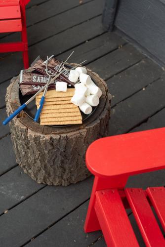 a wooden stump with a table and a red chair at Modern Treetop Cabin by Lake Arrowhead Village in Lake Arrowhead