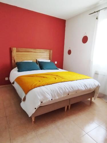 een slaapkamer met een groot bed met een rode muur bij Maison calme à proximité du Lac in Savines