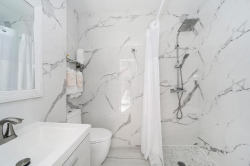 a white bathroom with a shower and a toilet at Deco Boutique Hotel in Fort Lauderdale