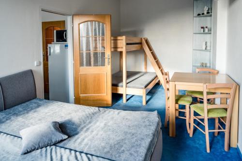 コウティにあるApartmány Červenohorské sedloのベッド、デスク、二段ベッドが備わる小さな客室です。