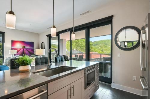 a kitchen with a sink and a living room at Supreme Downtown Condo in Asheville