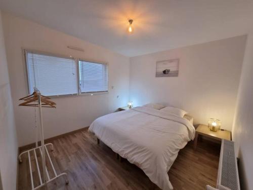 a white bedroom with a bed and a window at VILLA ROSA PARK in Guipavas