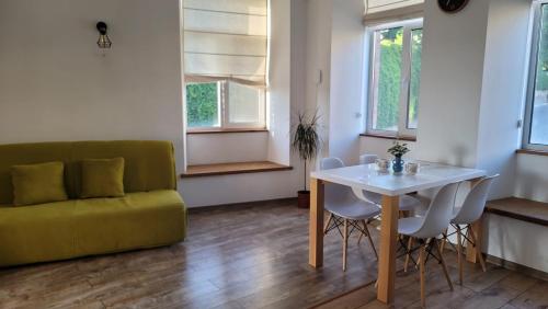 uma sala de estar com um sofá, uma mesa e cadeiras em Апартаменти біля Фортеці em Kamianets-Podilskyi