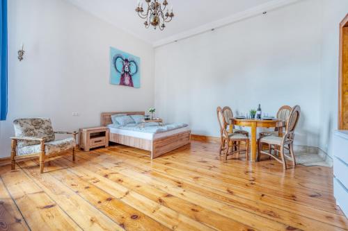 a room with a table and chairs and a bed at Piotrkowska OFF Apartments by Rentujemy in Łódź