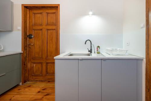 a kitchen with a sink and a wooden door at Piotrkowska OFF Apartments by Rentujemy in Łódź