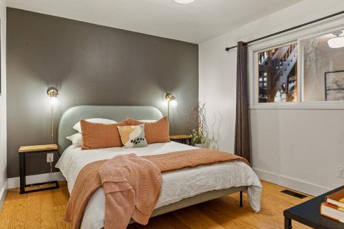 a bedroom with a bed with orange pillows at Modern Treetop Cabin by Lake Arrowhead Village in Lake Arrowhead