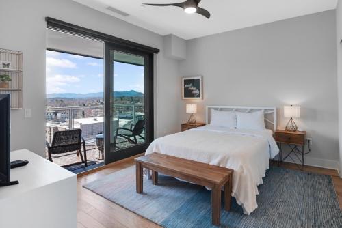 a bedroom with a bed and a large window at Modern Condo on South Slope in Asheville