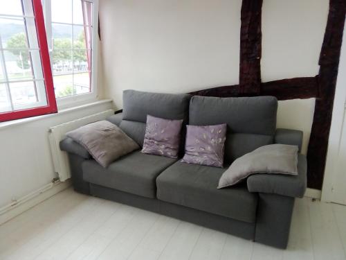 a couch in a room with pillows on it at ATICO TORRONTERO in Mundaka