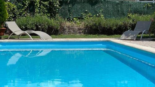two chairs sitting next to a swimming pool at Hotel Alfonso IX in Sarria