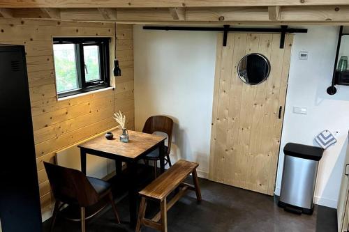 Habitación con mesa, sillas y puerta en Tiny House Old Oaks en Hulshorst