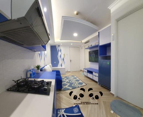a kitchen with blue and white cabinets and a stove at Apartment Kalibata City by PanBul in Jakarta