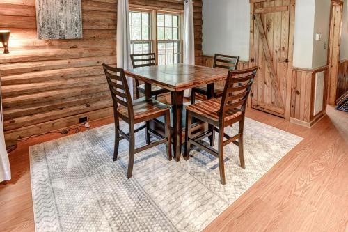 a dining room with a wooden table and chairs at Charming Renovated Cabin with Fireplace in Arden