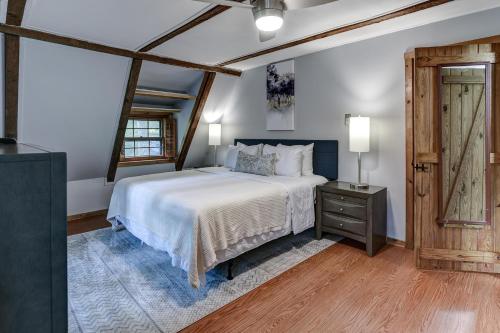a bedroom with a large bed and a wooden door at Charming Renovated Cabin with Fireplace in Arden