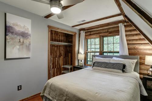 a bedroom with a bed and a wooden wall at Charming Renovated Cabin with Fireplace in Arden