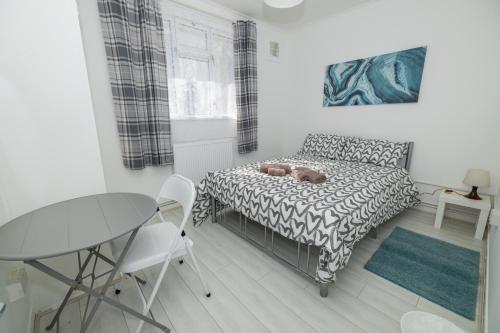 ロンドンにあるNice Rooms near Shoreditchのベッドとテーブルと椅子のある寝室