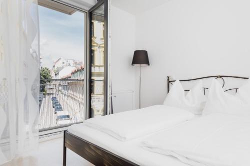ウィーンにあるRafael Kaiser - Paros Apartment - Contactless 24h Check-Inのベッドルーム(白いベッド1台、大きな窓付)