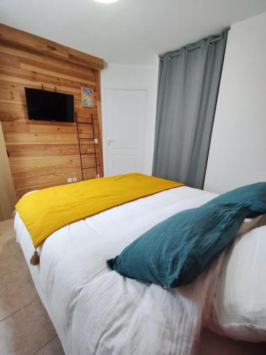 une chambre avec un grand lit avec une télévision au mur dans l'établissement Maison calme à proximité du Lac, à Savines