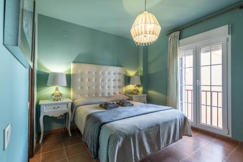 Schlafzimmer mit einem Bett und einem Kronleuchter in der Unterkunft Los Gavilanes by Ĥ in Isla Canela