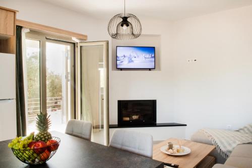 a living room with a table and a tv at Alonakia Home Suites in Filiatra