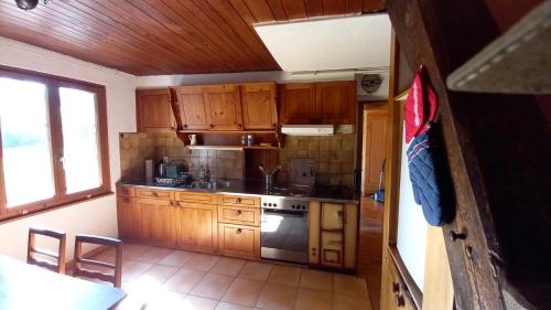 a kitchen with wooden cabinets and a stove at La Belle Etoile - Bauernhof in mitten der Natur in Souboz