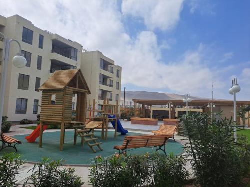 a playground with benches and a play structure at Hermoso departamento con piscina in Arica