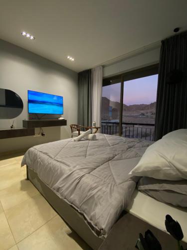 a bedroom with a large bed and a large window at aladnan Chalet alraha village in Aqaba