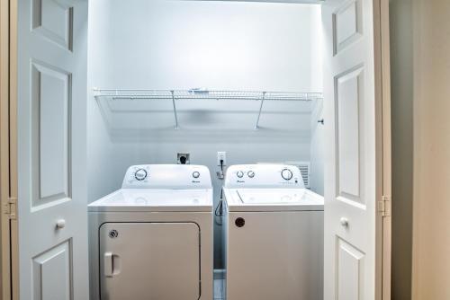 a white laundry room with two washes and a washer and dryer at South Asheville Townhome 16 A in Arden