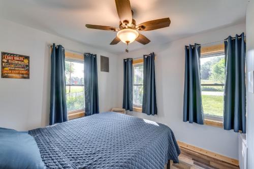 a bedroom with a ceiling fan and windows at Waterfront Lodi Vacation Rental on Lake Wisconsin! in Lodi