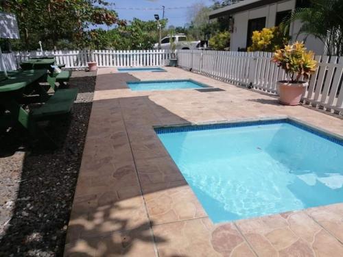 een zwembad in een achtertuin met een wit hek bij Villa 2 Coral Carrillo in Hojancha