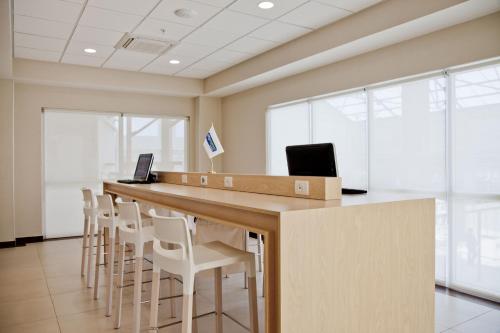 an office with a long bar with white chairs at City Express by Marriott Apizaco in Apizaco
