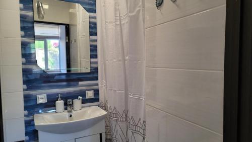a bathroom with a sink and a shower curtain at Апартаменти біля Фортеці in Kamianets-Podilskyi