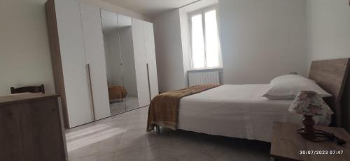 Habitación blanca con cama y espejo en Alloggio tra Terni e Narni, en Terni