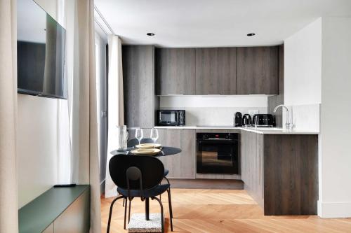 - une cuisine avec une petite table dans une pièce dans l'établissement Elegant studio - 2P - Opéra Garnier, à Paris