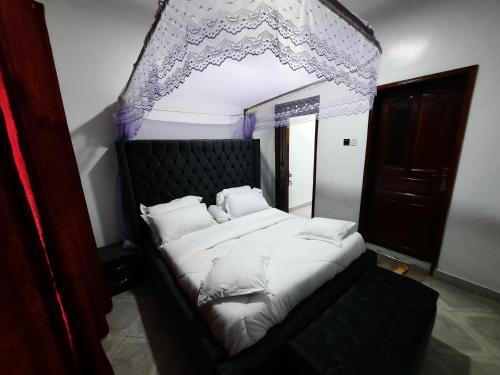 a bedroom with a large bed with a canopy at Deerwood Family Apartments, Bulenga in Bulenga