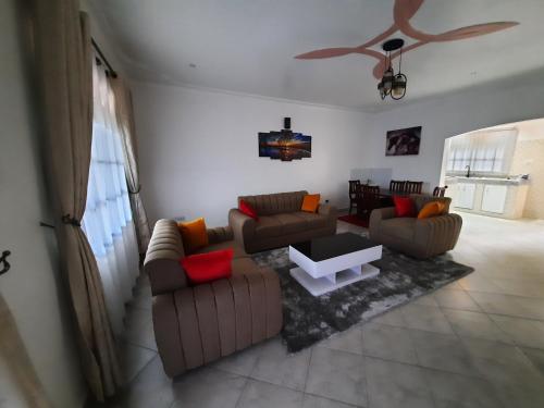 a living room with two couches and a coffee table at Deerwood Family Apartments, Bulenga in Bulenga