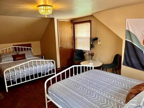 1 Schlafzimmer mit 2 Betten, einem Tisch und einem Stuhl in der Unterkunft Jennings in Cuyahoga Falls