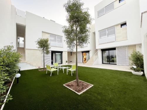 einen Garten mit einem Baum in der Mitte eines Gebäudes in der Unterkunft Corte Cesarina in Porto Cesareo