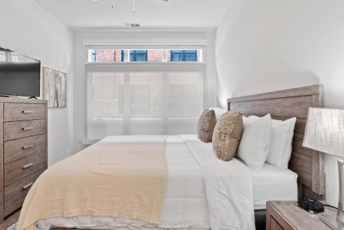 a white bedroom with a bed with a window at 55 South Market Condo 215 in Asheville
