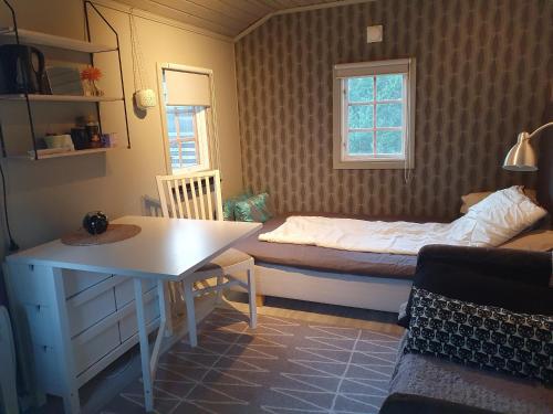 1 dormitorio con cama, mesa y ventana en Norrtälje, en Norrtälje