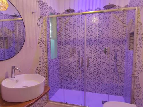 a purple bathroom with a sink and a shower at Le Dune Luxury Rooms in Vieste