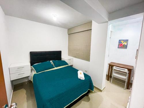 1 dormitorio con 1 cama con edredón azul en Dpto en Huanchaco a 100m de la playa, en Huanchaco