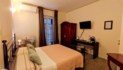 sypialnia z łóżkiem, biurkiem i telewizorem w obiekcie il Sole di Baggio w Mediolanie