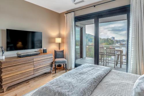 a bedroom with a bed and a large window at Outstanding Luxury Downtown Condo in Asheville