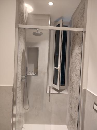 una doccia con porta in vetro in bagno di La Casa di Linda a Genova